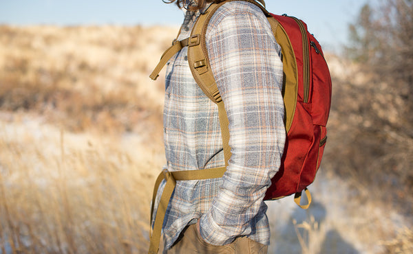 A profile shot of a person wearing the Guide's Edition Synapse 25 with the sternum strap and hip belt buckled.